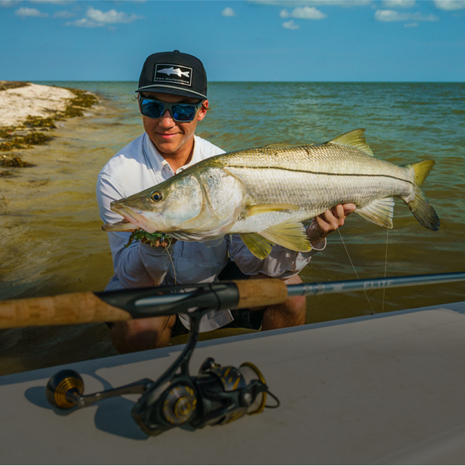 man with fish caught using elite inshore rod