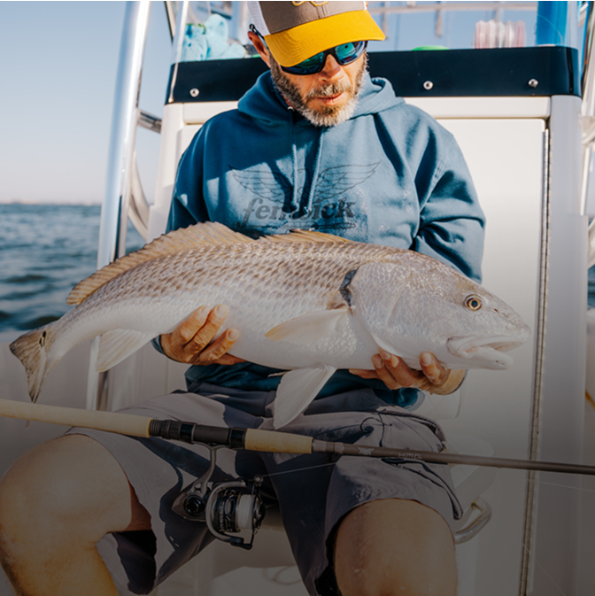 man holding fish caught with HMG fishing rod